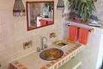 Orange bathroom which has a Jacuzzi tub and a stained glass window to the pool deck